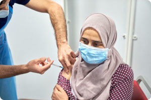 woman in hijab receives covid-19 vaccination